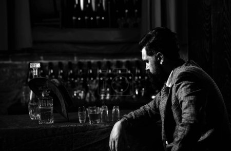 Photo for Portrait of a bearded man, with a glass of alcohol in his hands. Rest and relaxation in pub or bar - Royalty Free Image