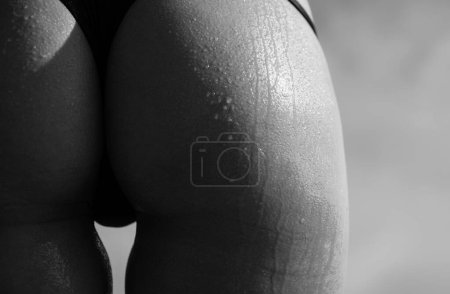Photo for A gorgeous young woman in bikini with a sexy ass. Advertisement silicone implants. Buttocks ass close-up - Royalty Free Image