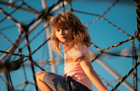 Photo for Children playground in urban park. Child climbing the net. Kids play and climb outdoors on sunny summer day - Royalty Free Image