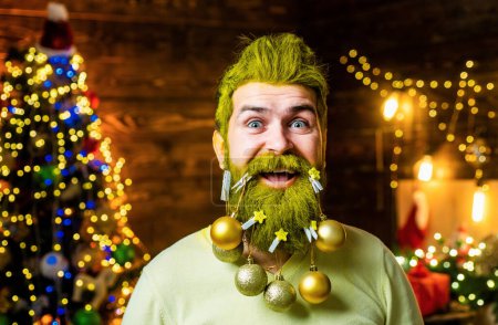 Téléchargez les photos : Joyeux Père Noël habillé en vêtements d'hiver pensez à Noël près de l'arbre de Noël. Père Noël avec une barbe blanche posant sur le fond en bois de Noël - en image libre de droit