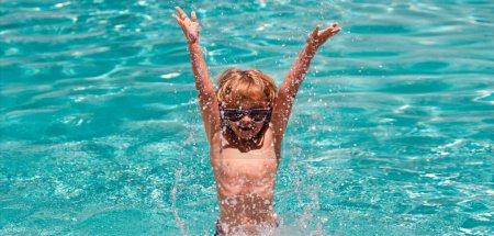 Foto de Excited child boy in sunglasses splashing in pool . Kid boy swim in swimming pool. Banner for header, copy space. Poster for web design - Imagen libre de derechos