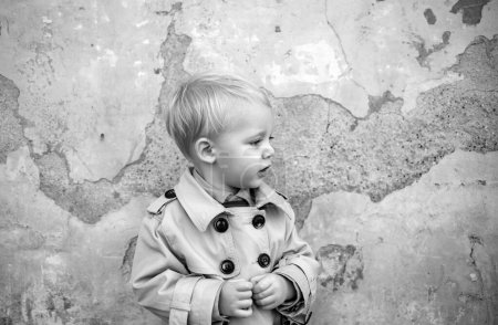 Photo for Small kid on grunge background. happy childhood. little boy in vintage coat. Beauty. childrens day. retro style. retro fashion look. vintage fashion model kid. small boy child near old wall. - Royalty Free Image