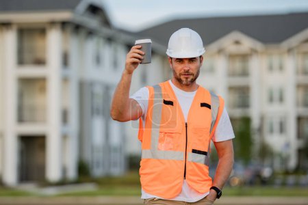 Photo for Caucasian man, construction worker in helmet at construction site. Engineer worker in hardhat near new home. Construction site manager, inspector - Royalty Free Image