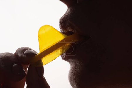 Photo for Lick and suck condom. Foreplay before love. Close up woman mouth holding condom. Love, sexuality and safe sex concept. Sensual sex with condom. Choice of safe sex protection. Oral sex with condom - Royalty Free Image