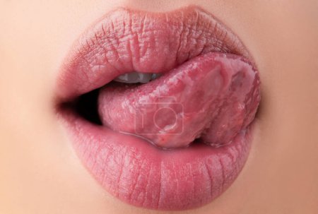 Téléchargez les photos : Léchage sensuel. La langue macro lèche les lèvres. Gros plan de la bouche de la femme - en image libre de droit