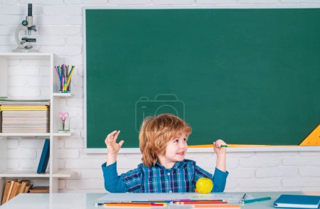 Photo for Child near chalkboard in school classroom. Happy school kids at lesson. School education and people concept - cute pupil over blackboard background - Royalty Free Image