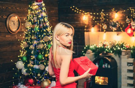 Téléchargez les photos : Beauté Noël mannequin fille tenant boîte cadeau de Noël. Sensuelle pour Noël. Joyeux Noël et bonnes vacances. Beauté fille de mode avec boîte cadeau de Noël - en image libre de droit