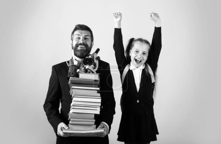 Photo for Father or teacher hold big stack school textbook notebook books. Happy excited preteen girl wears school uniform holding backpack isolated on pink, portrait - Royalty Free Image