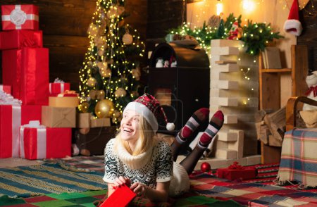 Téléchargez les photos : Joyeux Noël et bonne année. Pull tricoté confortable femme profiter de l'atmosphère de Noël à la maison. Cadeau de Noël pour ma chérie - en image libre de droit