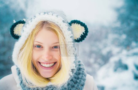 Téléchargez les photos : Beau portrait hivernal de jeune femme dans les paysages enneigés d'hiver. Portrait de femme d'hiver extérieur. Modèle portant un chapeau d'hiver tricoté élégant et des gants - en image libre de droit