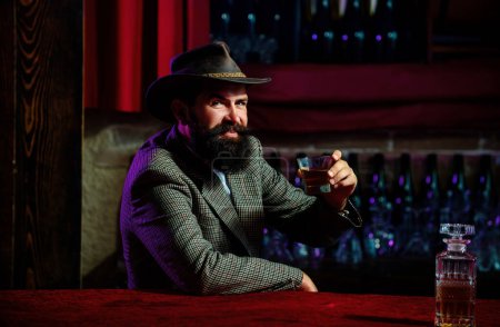 Photo for Man with beard holds glass brandy. Bearded guy drink cognac. Man holding a glass of whisky. Sipping whiskey. Portrait of man with thick beard. Macho drinking. Degustation, tasting - Royalty Free Image