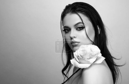 Foto de Hermosa cara de mujer y flor. Chica y rosa rosa. Retrato de cerca, cuidado de la piel, maquillaje - Imagen libre de derechos