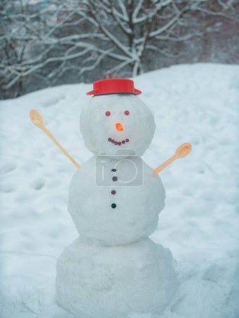 Foto de Escena de invierno con muñeco de nieve sobre fondo blanco. Saludo muñeco de nieve. Divertidos muñecos de nieve. Muñeco de nieve sobre un fondo cubierto de nieve ramas de abeto. Día del muñeco de nieve y nieve - Imagen libre de derechos