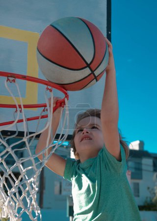 Photo for Healthy children lifestyle. Basketball kid player running up and dunking the ball - Royalty Free Image