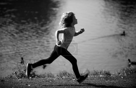 Téléchargez les photos : Les enfants courent dehors. Enfant coureur joggeur courir dans la nature. Bonjour, jogging. Mode de vie sain et actif des enfants - en image libre de droit