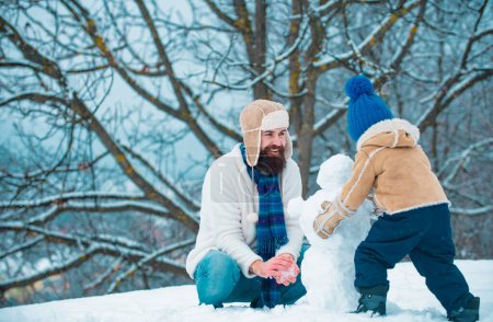 Téléchargez les photos : Heureux père et fils jouent pendant la période hivernale de Noël. Concept de famille amicale. Joyeux Noël et bonne année - en image libre de droit