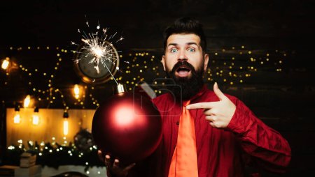 Photo for Sparkle blast. Christmas Celebration holiday. Hipster Santa claus. Christmas man in fashion red dress hold bomb. Creative boom. Hipster Santa claus - Royalty Free Image