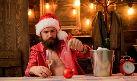 Foto de Hermoso Papá Noel de Navidad. Hipster Santa. Hombre bebiendo champán y celebrando el Año Nuevo. Fondo de Navidad de madera - Imagen libre de derechos
