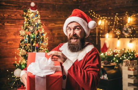 Foto de Regalos de entrega. Emociones de regalo. Hombre de Santa sosteniendo regalo. Loco, divertido Hipster Santa - Imagen libre de derechos