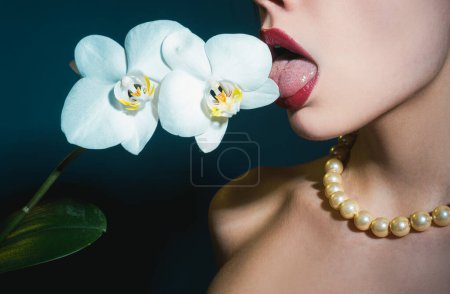 Photo for Sexy girl lick orchid flower. Orchids oral tongue. Sensual young woman suck floral orchidea - Royalty Free Image