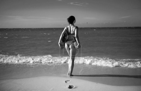 Foto de Hermosa chica modelo sexy en bikini en la playa de la isla tropical. Viaja vacaciones de verano en phuket o barbados. Mujer sexy sosteniendo piñas, vista en la espalda - Imagen libre de derechos