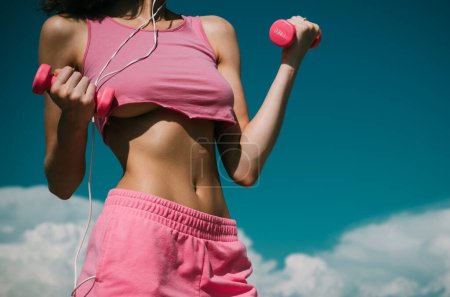 Photo for Sexy fitness woman. Healthy sports lifestyle. Athletic young woman in sports dress doing fitness exercise with pink dumbbells - Royalty Free Image