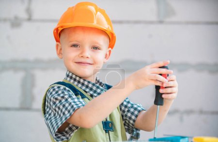Photo for Child in building helmet, hard hat. Child dressed as a workman builder. Portrait happy smiling little builder in hardhats. Little builder in helmet - Royalty Free Image