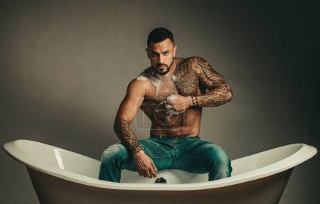 Téléchargez les photos : Homme sexy avec lavage du corps nu dans la baignoire - en image libre de droit