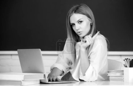 Photo for Female student on lesson lecture in classroom at high school or college. Beautiful caucasian female student is studying in college remotely, distance learning, online education - Royalty Free Image