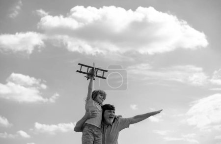 Téléchargez les photos : Vieux grand-père et jeune enfant petit-fils s'amuser avec avion en plein air sur fond de ciel avec espace de copie. Enfant rêve de voler, enfance heureuse avec grand-père - en image libre de droit
