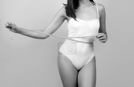 Photo for Perfect slim body. Woman weight loss. Woman holding the meter and measuring waist - Royalty Free Image