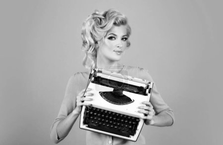 Foto de Mujer de negocios, oficina de secretaria retro con gafas vintage y máquina de escribir, secretaria contable. Pin up chica escribiendo en una máquina de escribir - Imagen libre de derechos