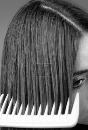 Foto de Close up brushing Hair. Portrait young woman brushing straight natural hair with comb. Girl combing veautiful long healthy hair with hairbrush. Hair care beauty concept - Imagen libre de derechos