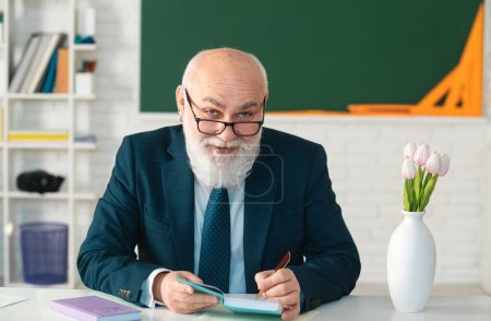 Téléchargez les photos : Professeur senior masculin avec des lunettes regardant la caméra, souriant et heureux - en image libre de droit