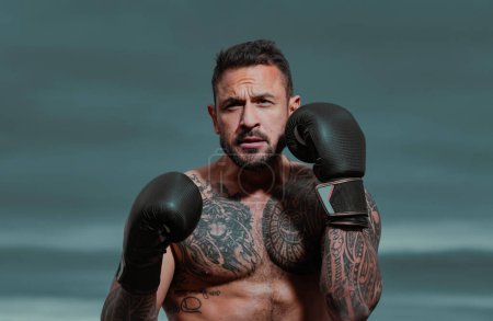 Photo for Boxer practicing punches in boxing. Boxer punching in boxing gloves. Sporty man during boxing exercise. Strength and motivation. Boxing training outside - Royalty Free Image
