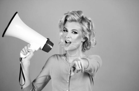 Photo for Speaking loudly in the megaphone. Attractive woman with megaphone pointing finger to the front - Royalty Free Image
