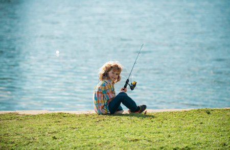 Foto de Pasatiempo de niños. Niño pescando en el lago. Chico con spinner en el río. Retrato de niño emocionado pescando. Chico en embarcadero con varilla - Imagen libre de derechos