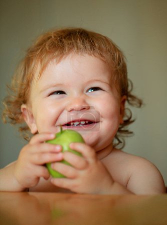 Téléchargez les photos : Souriant bébé heureux avec des pommes. Bon appétit. Alimentation saine et concept enfant. Lancement de manger enfant - en image libre de droit