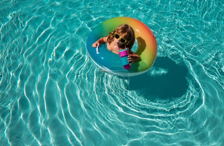 Foto de Niño de verano en piscina de natación en anillo de círculo de goma inflable. Verano niños fin de semana o vacaciones - Imagen libre de derechos