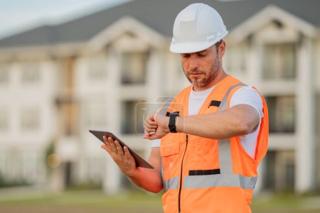Photo for Engineer with tablet, building inspection. Serious engineer at new home. Construction manager in helmet. Architect at a construction site. Handyman builder in hardhat - Royalty Free Image
