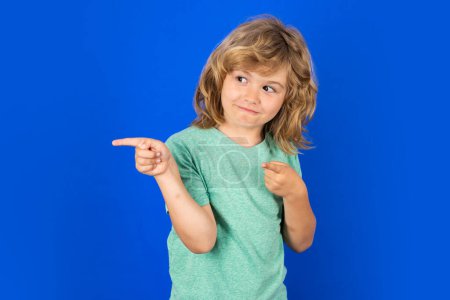 Photo for Child boy pointing away on isolated studio background. Kid with index finger pointing, copyspace - Royalty Free Image