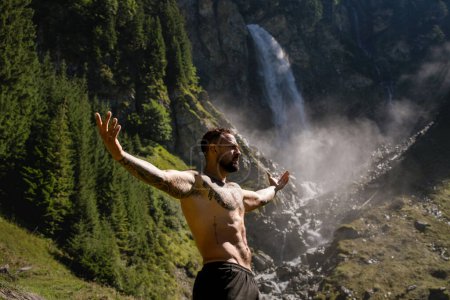 Photo for Sexy man in Alps waterfall. Man freedom lifestyle in nature. Hispanic man summer on nature. Calmness and relax in nature. Man under mountain river waterfall, rose arms up and enjoying splashing - Royalty Free Image