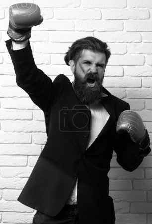 Photo for Hard business. Funny excited businessman in boxing gloves. Crazy man boxing. Young man in a suit and boxing gloves, celebrating a win. Leadership concept - Royalty Free Image