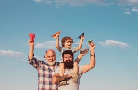 Téléchargez les photos : Papa et fils. Père et fils jouent sur le ciel bleu de l'été. Concept de fête des pères. Multi génération - en image libre de droit