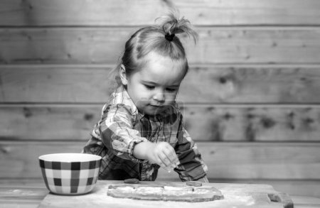 Photo for Little baker child at kitchen. Baby boy in the kitchen helping with cooking, playing with flour - Royalty Free Image