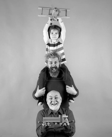 Photo for Fathers day. Kid having fun with toy plane. Men generation family with three different generations ages grandfather father and son. Family adventure, imagination and innovation inspiration concept - Royalty Free Image