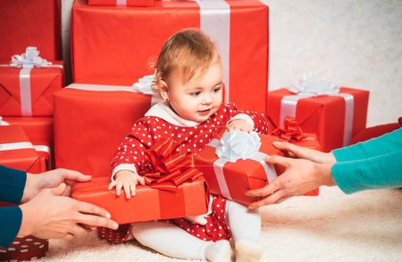 Foto de Lindo niño sostiene la caja de regalo. Concepto de celebraciones. Lindos bebés con una caja de regalo roja sobre fondo blanco. Niños felices - Imagen libre de derechos