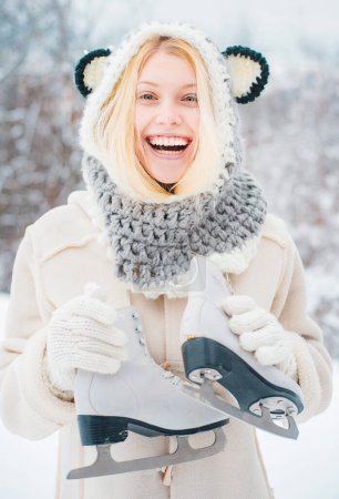 Photo for Beauty Joyful Girl having fun in winter park. Beautiful smiling young woman in warm clothing with ice skates. Winter landscape background. Winter young woman portrait - Royalty Free Image