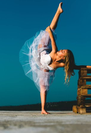 Photo for Art ballet. Young ballerina, ballet dancer. Leg-split, flexible girl doing split. Woman doing stretching up exercise outdoors - Royalty Free Image