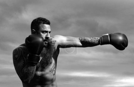Foto de Boxeador entrenando al aire libre. Deportista muay thai boxeador luchando con guantes. Hombre deportivo durante los ejercicios de boxeo. Concepto de fuerza, ataque y movimiento. Boxeador punzón en movimiento - Imagen libre de derechos